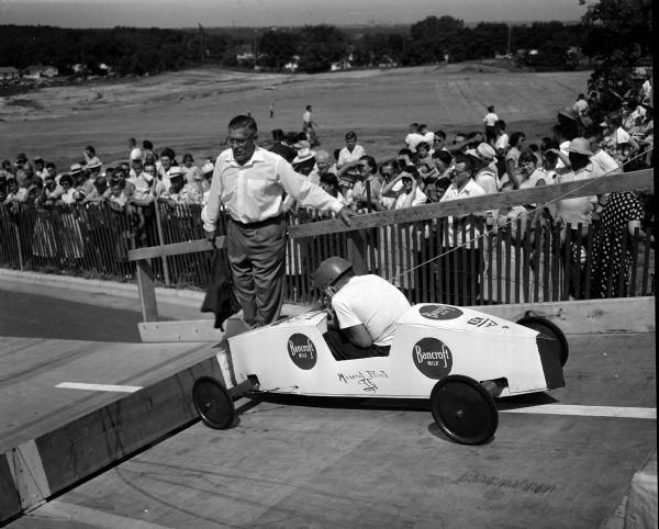 Racer Ken Johnson of Mineral Point waits for the starting signal from city recreation director Glenn Pat Holmes at the 1954 Madison soap box derby.