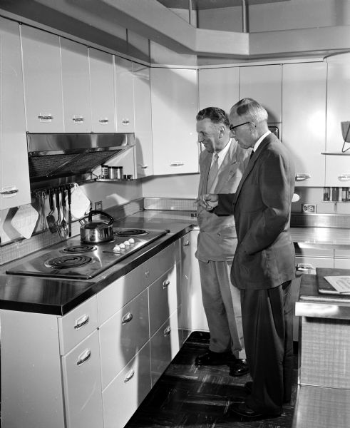 The "heart kitchen" at Madison Vocational school, a Red Feather service, is inspected by two volunteer officials of the United Givers Fund campaign. Left to right: L.J. Markwardt, assistant director of Forest Products Laboratory, and Arthur E. Wegner, financial secretary to Governor Kohler.