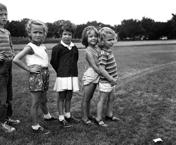 Children wait their turn for a pony ride at Franklin playground. Left to right: Cinda Helleckson, Janice Schaub, Margo Kanvik, and Debby Aberle. The boy at far left is unidentified.