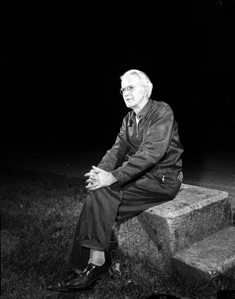 Portrait of Ulmont Healy, seated on a step. He is the director of the Mineral Point Players' production of Shakespeare's "A Midsummer Night's Dream."