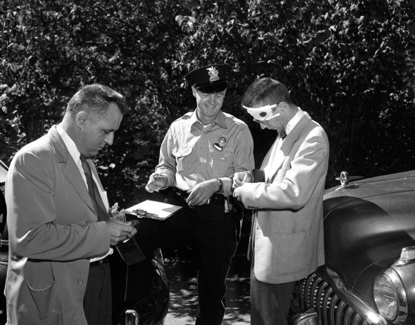 University of Wisconsin law professor George Young (left) and assistant professor James B. MacDonald, along with University police officer Dwight Brown, play roles in a simulated automobile accident as part of a training project.