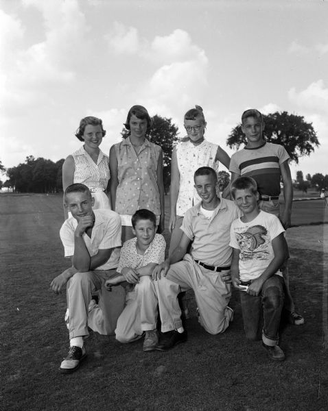 Group portrait of the winners of the Madison Inter-Club Junior Golf Tournament held at the Maple Bluff Country Club. Back row, left to right, are: Judy Smith, Nakoma; June Zeiler, Maple Bluff; Carolyn Britton, Nakoma; and Craig Washa, Blackhawk. Front row, left to right, are: John Neupert, Blackhawk; Dave Pearson, Blackhawk; Irwin Smith, Nakoma; and Brad Walwrath, Maple Bluff.