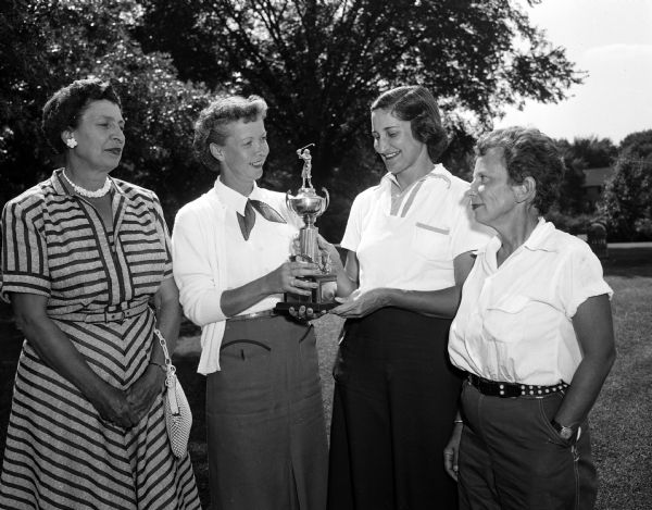 Group portrait of several Blackhawk Country Club women after they won the Inter-Club Golf Team Play Dr. W.G. Beercroft traveling trophy. Pictured are Violet Johnson, Nakoma; Irene Dettloff, president of the Blackhawk; Charlene Larson, chairman of the Blackhawk Inter-Club play and Elynore Wegner, Nakoma. Isabell Greene of Maple Bluff is general chairman of the InterClub play.