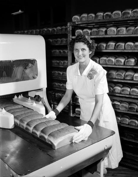 Mabel Pope, assistant secretary of the Local 233 Bakers and Confectioner's Union, operates a bread-wrapping machine at the Kroger Bakery, located at 1053 East Washington Avenue.