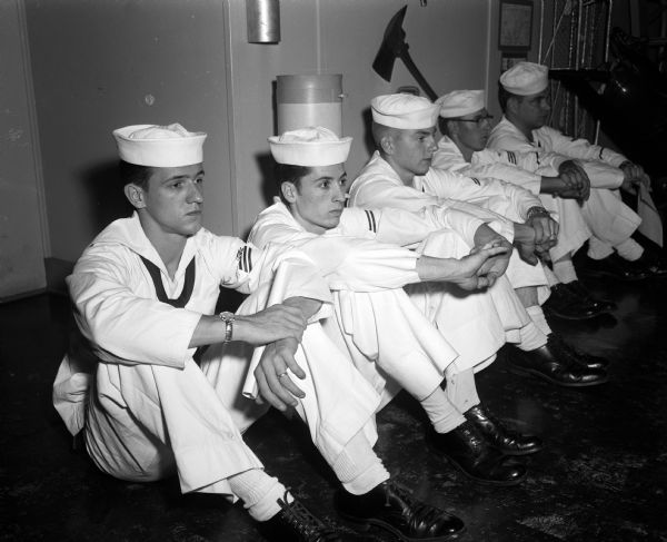 Members of the Madison Naval Reserve Surface Division watch a training movie at the Naval Reserve Training Center at 1046 East Washington Avenue. From left are: Bruce Precourt, Dale Crain, Marlowe Suter, and two unidentified men.