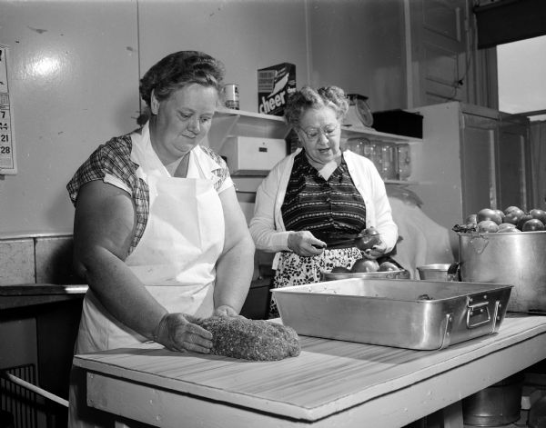 Cook Mrs. Clara Lehr and her assistant Mrs. Betty Hungate preparing lunch at Sunnyside School at 3902 East Washington Avenue.