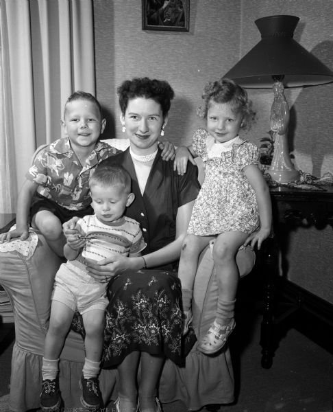 Portrait of Mrs. Felix J. (Phyllis) Gryskiewiez and her three children. She and her husband are visiting her parents, Mr. and Mrs. P.H. Mickle.