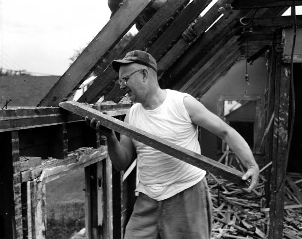 A member of Bashford Methodist Church, 15 North Seventh Street, tears down the house at 329 North Street where the new church will be located. Harold Bohmsack is shown removing rafters.