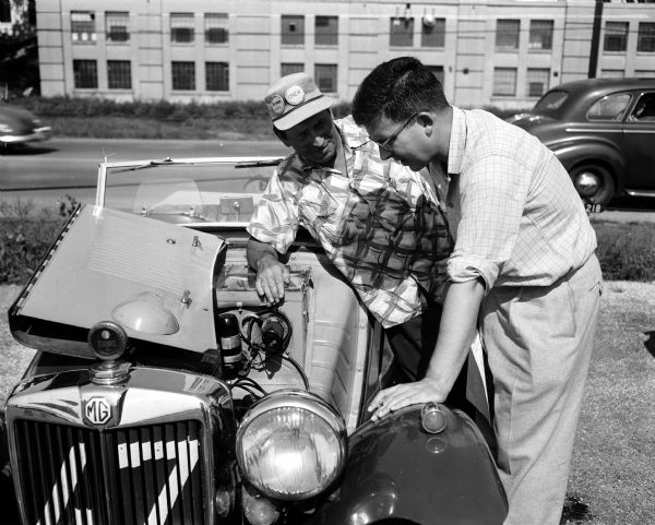 Visitors to the Madison Sports Car Club for a "rallye." L.W. Schouppner (left) of Melrose Park, Illinois, and Don Doman of Janesville, are inspecting a British built MG.