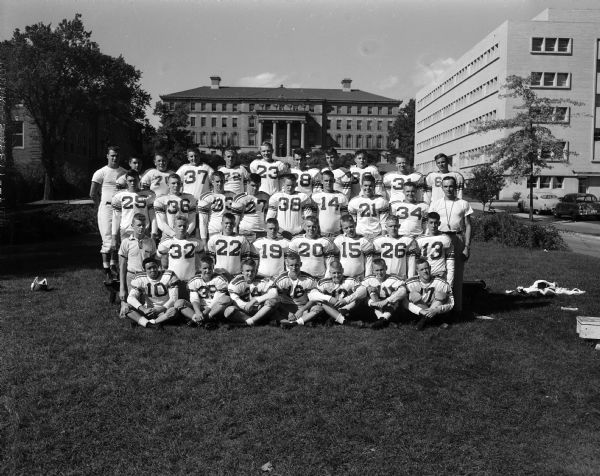 Group portrait of Wisconsin High football team. The University of Wisconsin Agriculture Hall can be seen in the background.