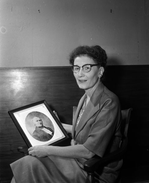 Miss Alice Smith holds a portrait photo of James Duane Doty.