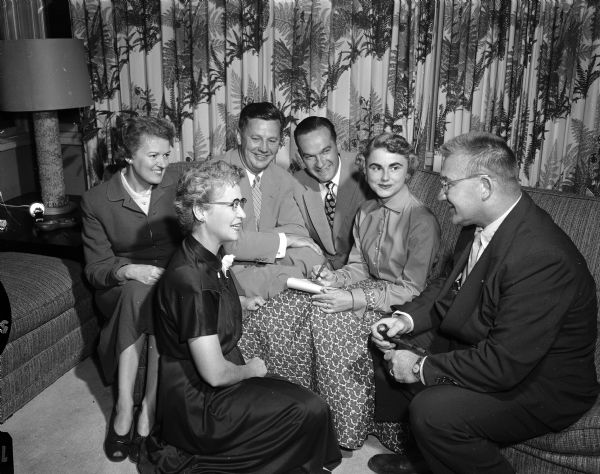 Portrait of three Madison couples taking prominent roles in sponsoring a program featuring two top United States salesmen. The event is sponsored by the Madison chapter of National Sales Executives. Left to right are: Mary Behnke, Helyn Malcolinson, Henry Behnke, Ernest and Emile Haar, and Floyd Malcolinson. Mr. Behnke is president of the Madison chapter and Mr. Haar is chairman of the program.