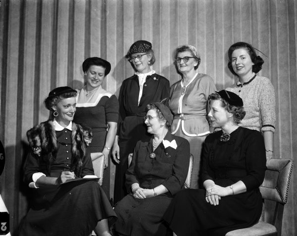 Group portrait of committee members for the semi-annual "Hand of Friendship" membership drive tea for the Wisconsin chapter of the American Business Women's Association. Seated, left to right, are Mrs. Grace Rooney, membership chairman; Miss Helene Blied, president; and Mrs. Evelyn Vollenburg,  banquet-social chairman. Standing, left to right, are Mrs. Edna Morris, publicity chairman; Miss Annette Rasmussen, recording secretary; Mrs. Marguerite Townley, program chairman; and Miss Betsy Donahue, membership committee.