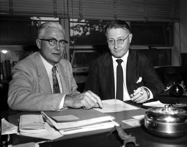 A.T. Rose (left), director of the Wisconsin State Employment Service, conferring with Don Larin, farm placement chief of the United States Employment Service, about a plan to assure Wisconsin agricultural industries a sufficient supply of seasonal labor.