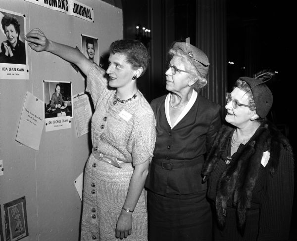 Elenor Shefferman, woman's editor of the <i>Wisconsin State Journal</i>, points to a display of woman's page features to Emily Pokorny of the Century Club and Helene K. Blied of the American Business Women's Club during the <i>Wisconsin State Journal</i> Publicity Workshop.