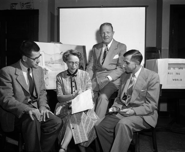Men gather to go over some of the new materials to be discussed at the upcoming Audio-Visual Institute for church school workers. They include, from left: Rev. Richard Snyder, First Congregational Church; Cleo DuBois, representing Methodist Churches; Ellis Dana, vice-president of the Wisconsin Council of Churches, and Erwin Reinhard, representing Lutheran churches.
