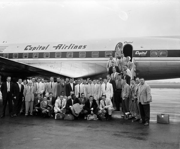 A group of men pose in front of Capital Airlines airplane at Madison Municipal Airport - Truax Field.