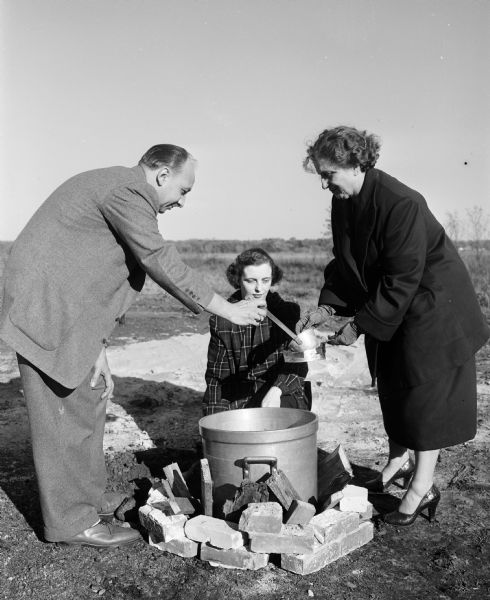 Eldred Heiser (left), Isabelle Hyslop, and Janet DePiazza gather around an oven/kettle intended for cooking soup, meats, and stews during a Civil Defense emergency mass-feeding practice.