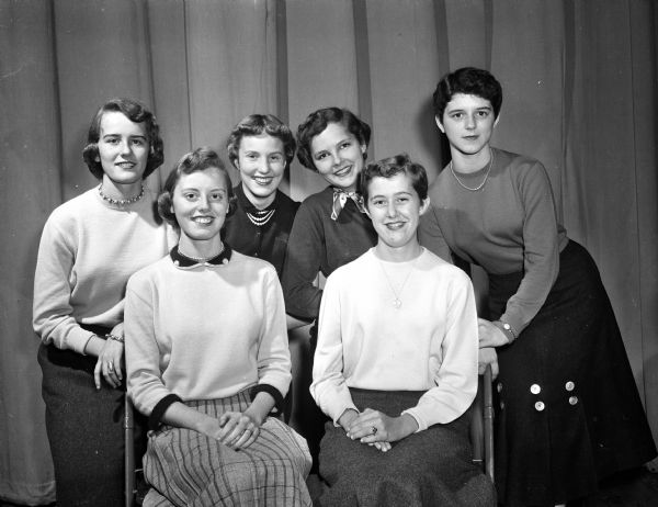 Group portrait of Central High School's Homecoming Queen with her Court of Honor. Queen Colleen Ryan is seated at right. At left is Susan Jeffrey, and standing left to right are: Ann Namio, Nancy Jones, Ann Gibson, and Patti Magli.