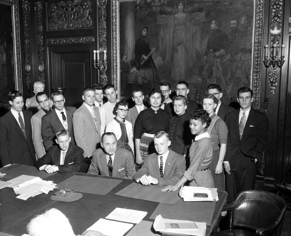 Members of the youth advisory board and the young adult board of the Governor's Commission on Human Rights gather around Governor Walter Kohler prior to a meeting paying tribute to his interest in youth and human rights. Seated left to right: Tom Mase, chairman of the young adult board; Governor Kohler; and Bill Thiesenhusen, chairman of the youth board. Standing at right is Shirley Johnson who reported on the group's activities in Beloit.