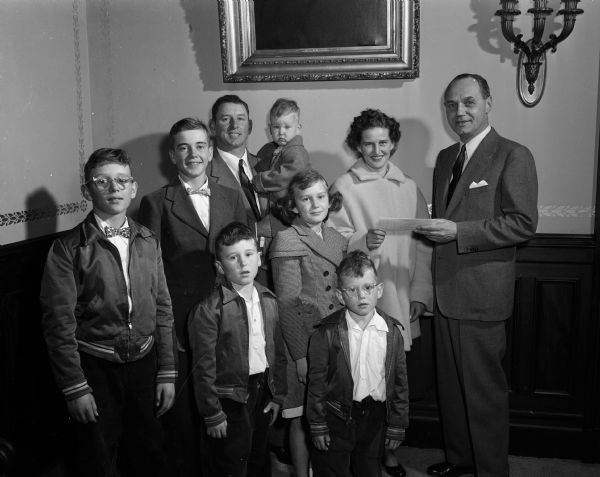 Governor Kohler poses with a farm family in his offices, including six children with parents.