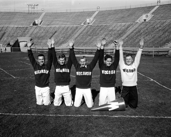 Posing in empty Camp Randall Stadium are the University of Wisconsin cheerleaders (left to right) Walter Koehler, Milwaukee; Robert Cotanch, Fond du Lac; Richard Onstad, Madison; Lee Geraldson, Manitowoc; and "boss man" Frank Worzala, Milwaukee.