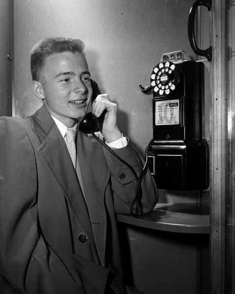Jerry Stich, East High School student, illustrates an important point in the "Madison High School Party Code" by telephoning his parents when unforeseen circumstances cause a delay in returning home.
