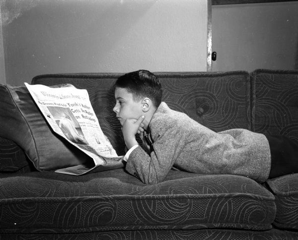 Monte Allen, age eight, reads about the need for donations for the Empty Stocking Club in the <I>Wisconsin State Journal</I>. The Club, sponsored by the <I>Wisconsin State Journal</I> newspaper, raises funds for Christmas toys for needy children in the Madison area.