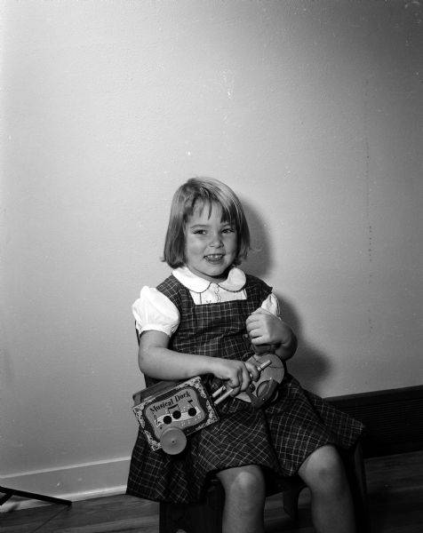 Marcia Holten, age 3 and a half, holds a Musical Duck pull toy she received from the Empty Stocking Club, as imagined in Monte Allen's dream. The Club, sponsored by the <i>Wisconsin State Journal</i> newspaper, raises funds for Christmas toys for needy children in the Madison area.