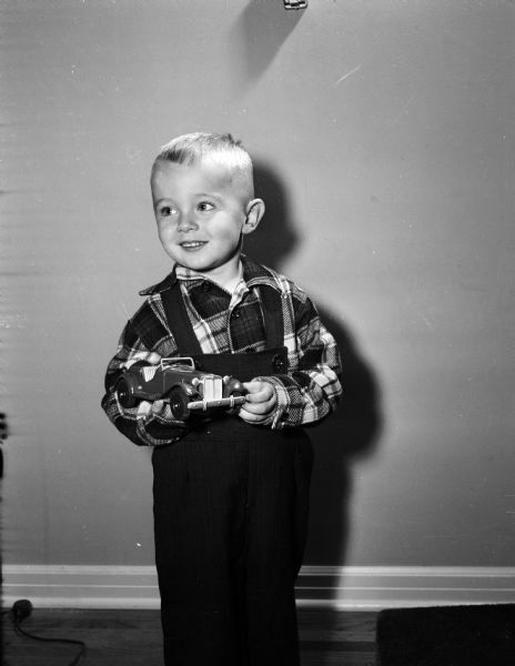John Prindle, age three, holds a toy car he received from the Empty Stocking Club, as imagined in Monte Allen's dream. The Club, sponsored by the <i>Wisconsin State Journal</i> newspaper, raises funds for Christmas toys for needy children in the Madison area.