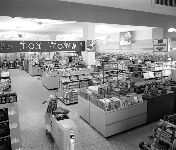 Elevated view of the toy department at the new Sears store, located at 1101 East Washington Avenue. A motor scooter is in the foreground.