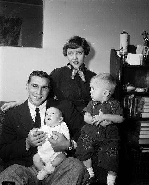 Portrait of Alan Ameche, University of Wisconsin All-American football fullback and winner of the Heisman Memorial trophy, with his wife Yvonne and their two sons, 17-month old Brian and 2-month old Alan.