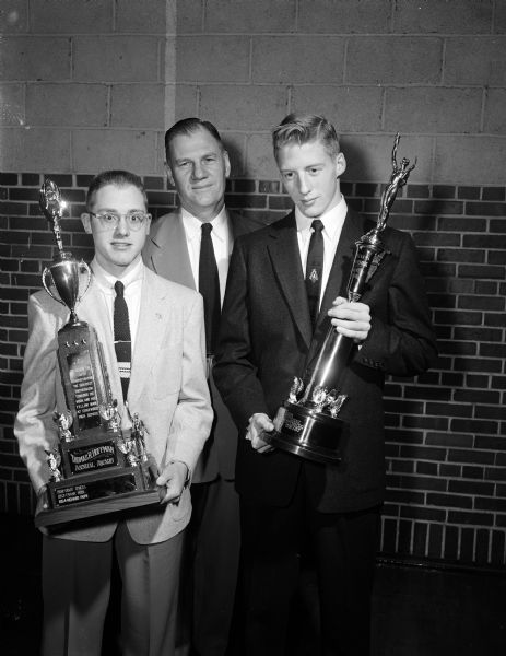Receiving trophies at the Edgewood High School football banquet are: Dick Pope, left, winner of the Tom Hoffman Trophy, and at right, George Chryst, winner of the Tom McCormick Trophy. At center is Earl Wilke, Edgewood High School football coach.