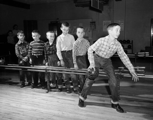 Larry Elliott (left), Jim Anderson, Donald Carpenter, Bob Nielsen, and Richard Hoebel watch as Bill Hoebel tries his luck bowling with a boy-size bowling ball at the Plaza Alleys in Madison.
