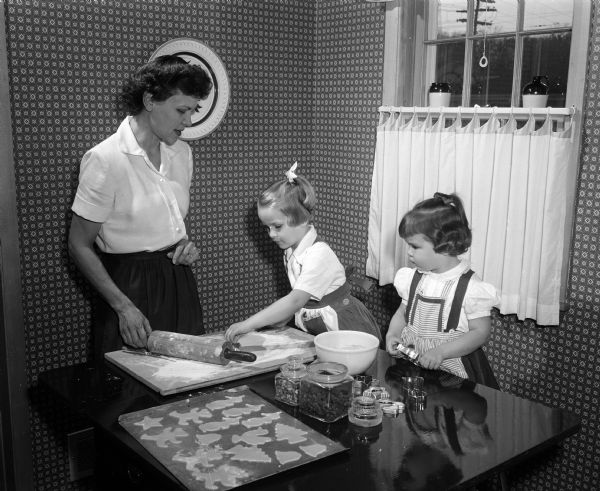 Jean Brickson and her daughters Ann, age 4, and Betty, age 2, make cut-out Christmas cookies.