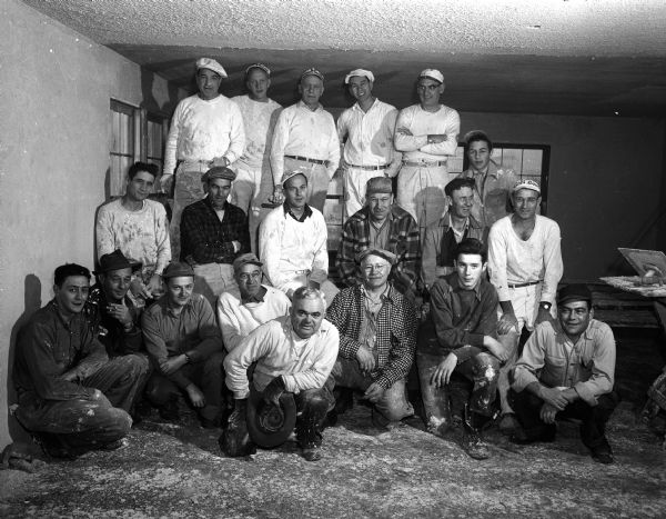 Group portrait of twenty men who volunteered their time to help remodel a home at 1129 Mound Street into a new convent for the nuns of St. James' Parish.