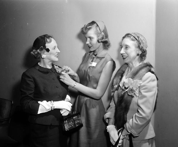 Barbara Boesel pins an orchid on national director Mrs. H.J. Potts of Waukesha during a Delta Delta Delta Sorority State Day meeting. Looking on is Mrs. W.P. Kramer of Wauwatosa, district chairman.