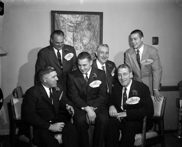 Group portrait of the principals at the University of Wisconsin Varsity Football Banquet. Front row, left to right: Milt Bruhn, the new head coach; Wells Gray, 1955 most valuable player; and Ivan Williamson, former coach and new athletic director. Back row: Harry Kipke, guest speaker; Wilfred Smith, toastmaster; and Pat Levenhagen, team captain for 1956.