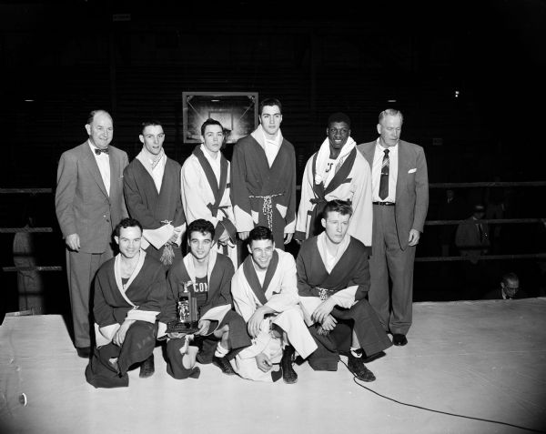 Group portrait of champions crowned at the twenty-second annual Tournament of Contenders boxing program at the University of Wisconsin. First row, left to right, are: Bob Sauter, Milwaukee; Frank Calarco, Milwaukee; Rolland Nesbit, Edgerton; and Bob Kelly, Philadelphia. Second row, left to right, are: coach John Walsh; Charles Edwards, Milwaukee; Ron Marshall, Richland Center; Bob Linke, Milwaukee; Al Walker, Rockford; and assistant coach Vern Woodward.