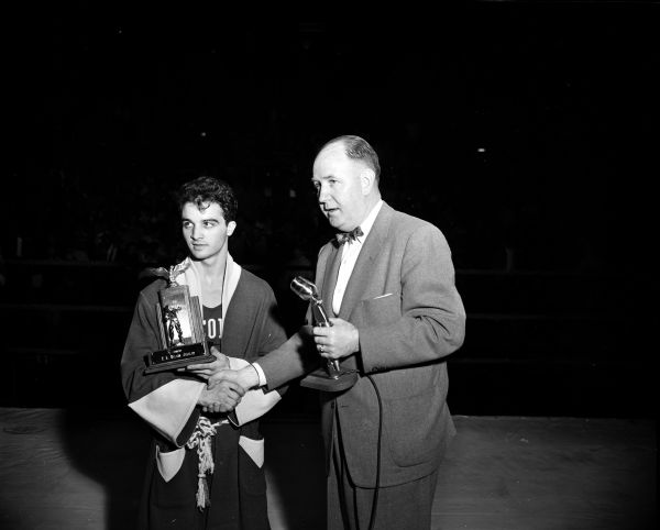 Frank Calarco, Milwaukee, receives the "Best Contender" trophy from coach John Walsh after the Tournament of Contenders boxing finals at the University of Wisconsin-Madison Field House. He won the 132-pound title for the second straight year.