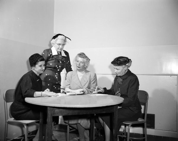 Four ladies sit at a small round table at Washington School.