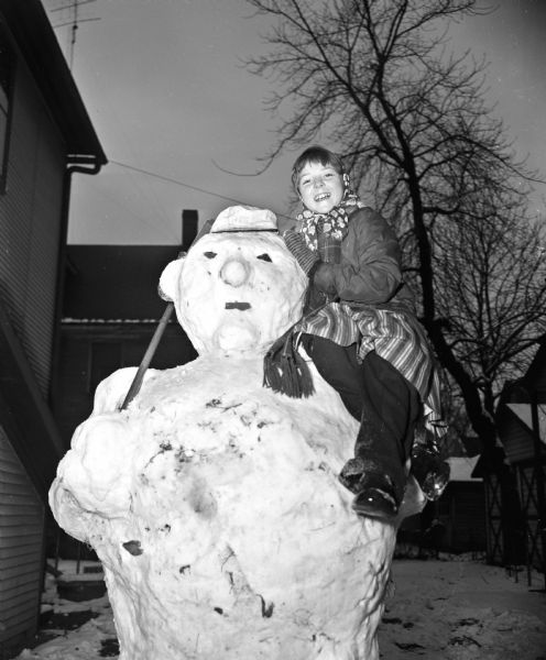 Winter scene with Patty Kosinski, of 205 North Frances Street, posing on the 8-foot snowman she and her friends built.