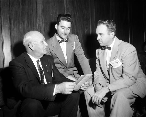 Discussing the program at the state meeting of the United Commercial Travelers insurance company are, left to right: Norval Anderson, Madison; La Verne Martin, Monona; and Wilbur Wiessanger, McFarland.
