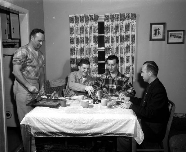 Madison Bachelors featured for Leap Year have dinner together at 1314 Jewel Street.  Left to right: Thomas Wright, Harry Kessenich, Jr., Robert "Bud" Paunach, and James Fagan.