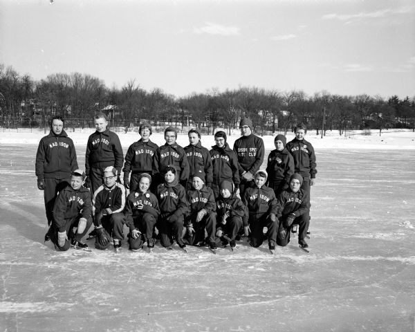 Members of the Madison Speed Skating club in their new Cardinal uniforms during a practice session at Vilas Park. The image shows 17 speed skaters posing in two rows; nine of them are girls and eight of them are boys.