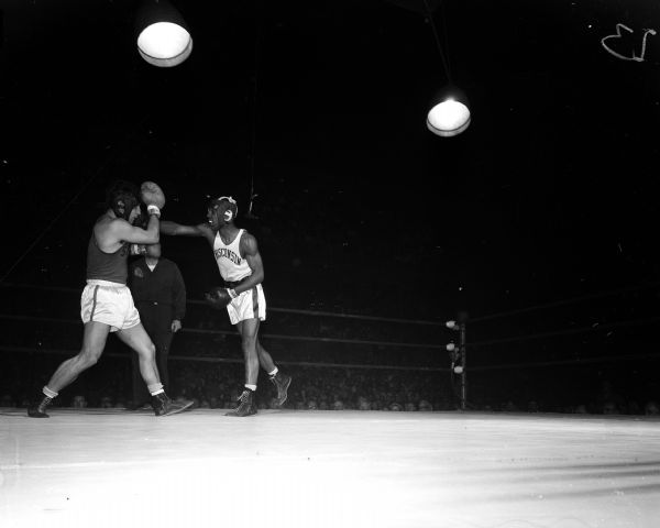 Action photo of University of Wisconsin boxer Orville Pitts (right) vs. Syracuse boxer Nick Georgiade at the Field House.