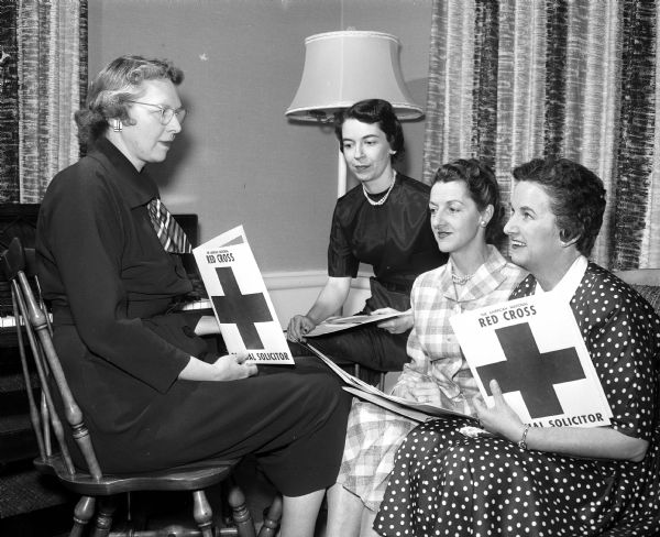 Four women are attending an organizational meeting of the Maple Bluff unit of the American Red Cross. Right to left: Elizabeth Mandeville, campaign chairman, and three captains, Mrs. Victor Arnold, Mary Holford, and Viola Breily.