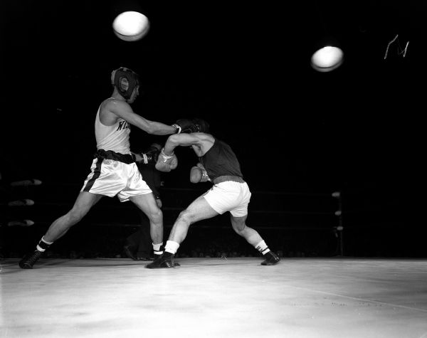 University of Wisconsin sophomore Jim Schneider, left, lands a punch on Tony Dibiase of Virginia University during the 156-pound bout of the intercollegiate boxing match.