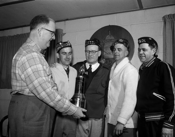 Madison Curling Club members during the Invitational Bonspiel at Lavern Harmon Rink. The Madison Curling Club received the Walter C. Rhodes Trophy for the first event. The men include, from left: Lavern Harman, Bob Mortenson, Willian Vea, and R. Seybold.