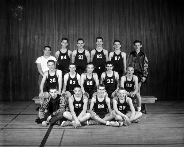 Group portrait of the East High School sophomore basketball team in uniform with their coach.